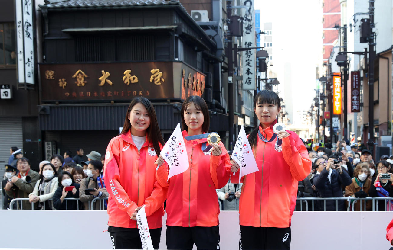 パリ五輪・パラのパレードで撮影に応じる、左からスケートボード女子パークの草木、女子ストリート金メダルの吉沢、銀メダルの赤間（撮影・柴田隆二）