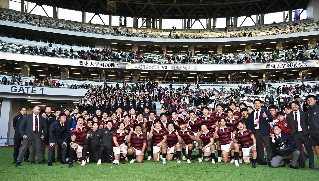 早大対明大　明大に勝利し応援団を背に記念撮影する早大の選手たち（撮影・滝沢徹郎）