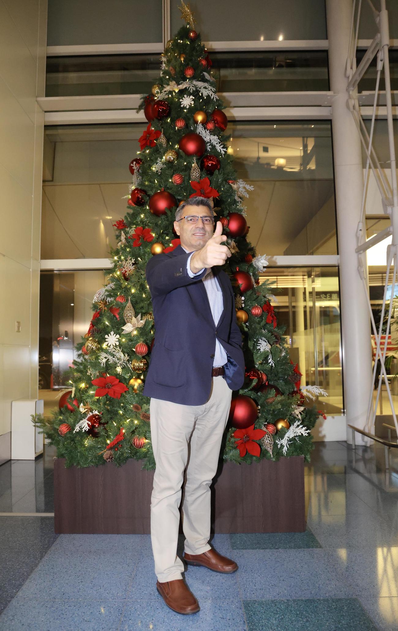 クリスマスツリーを背に、ポーズを決め写真に納まるパリ五輪射撃銀メダリストの、「無課金おじさん」ことユスフ・ディケチ（撮影・河田真司）