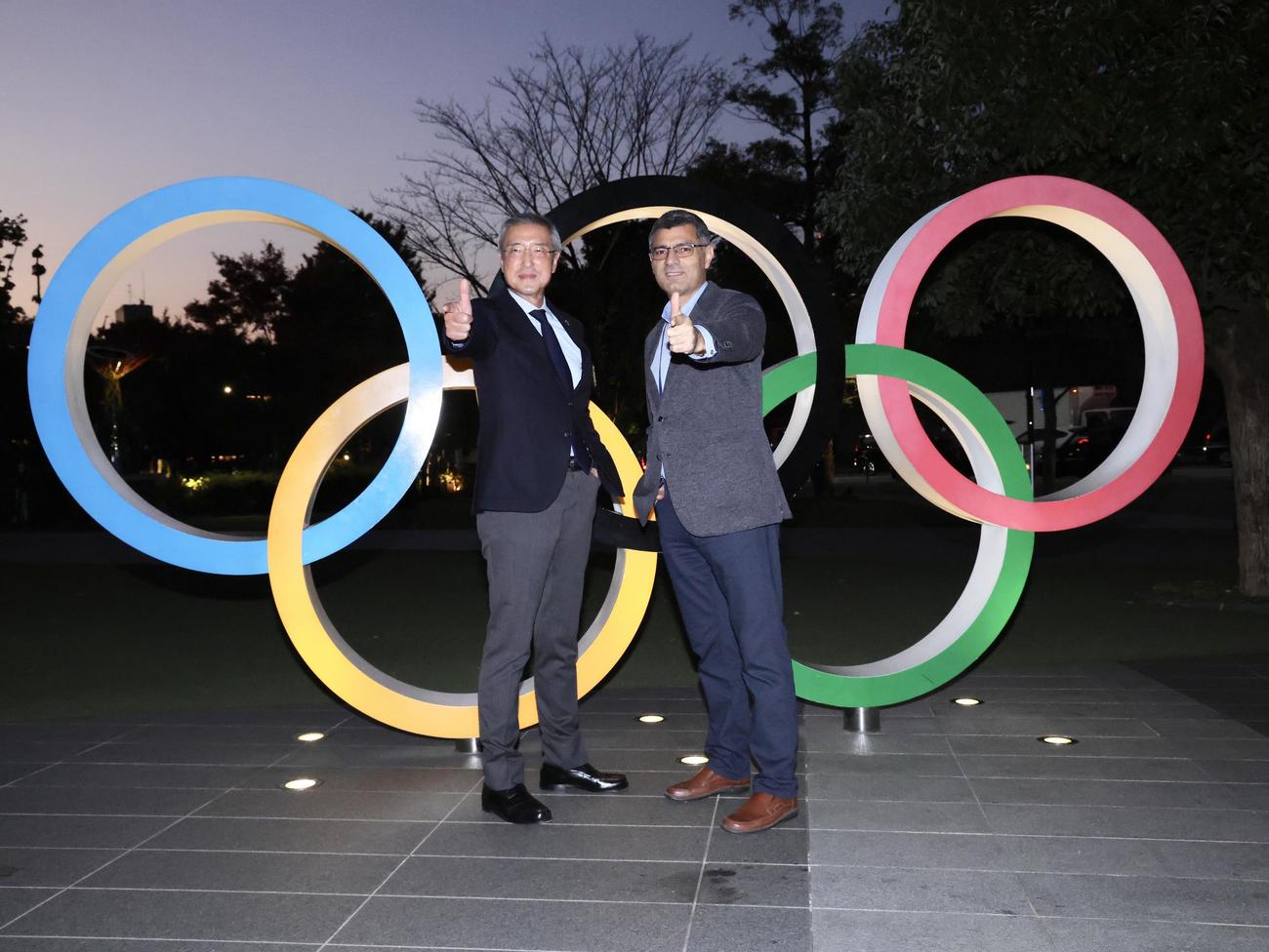 日本ライフル射撃協会松丸会長（左）と記念撮影する、パリ五輪射撃混合エアピストル銀メダリストの「無課金おじさん」ことユスフ・ディケチ（撮影・河田真司）