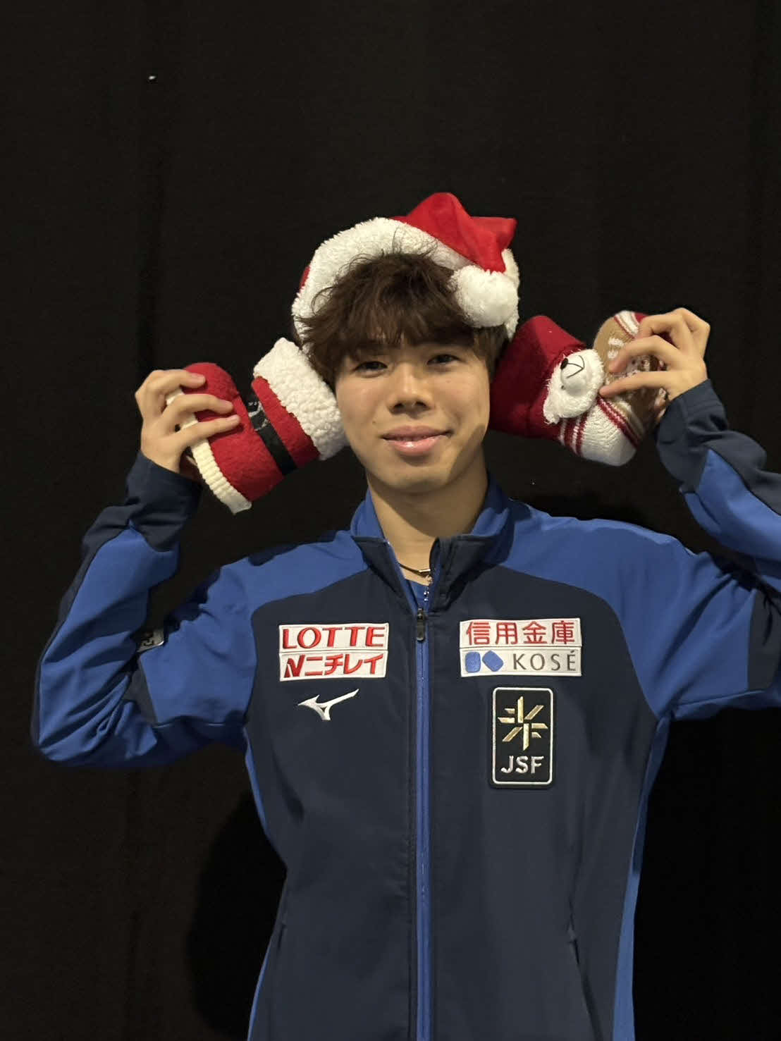 クリスマスをイメージしたグッズを手に笑顔の佐藤