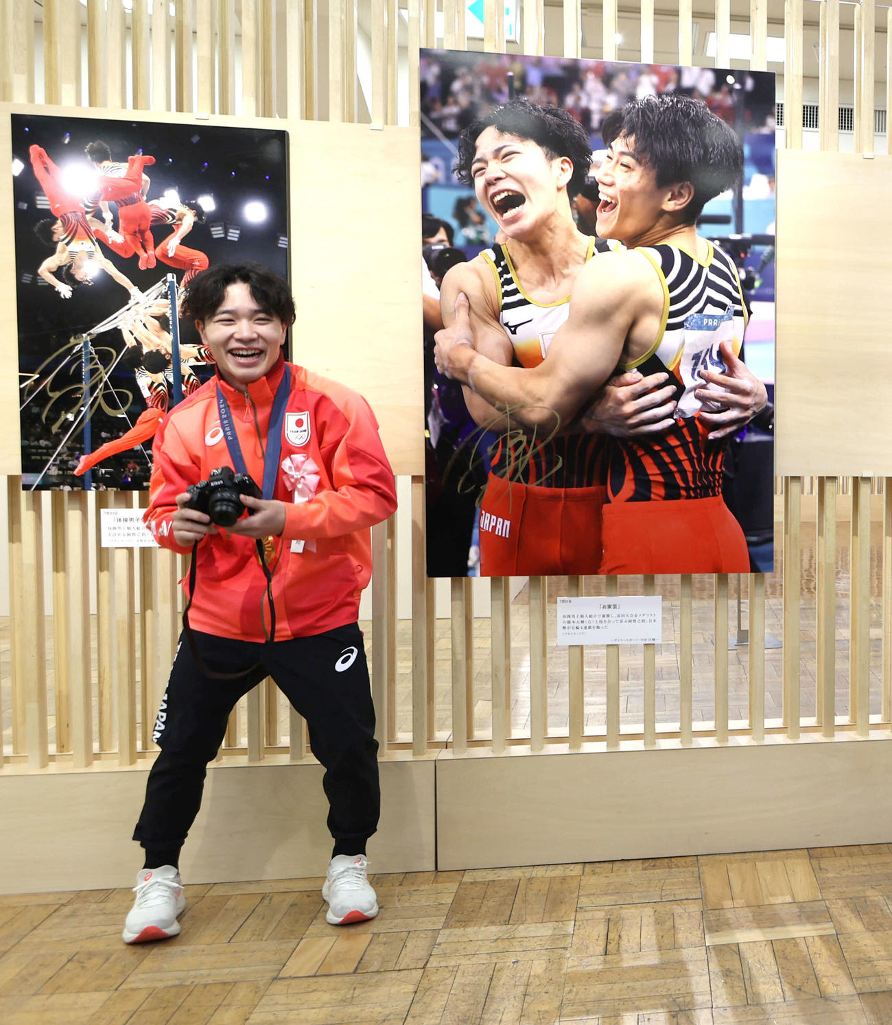 日本橋三越で開幕した「2024報道写真展」でカメラを手に笑顔を見せる岡（撮影・水谷安孝）