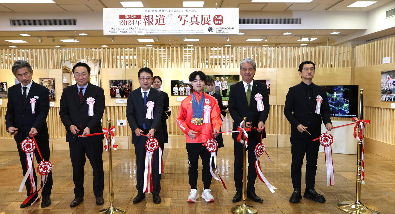 日本橋三越で開幕した「2024報道写真展」で岡（左から4人目）はオープニングのテープカットをする（撮影・水谷安孝）
