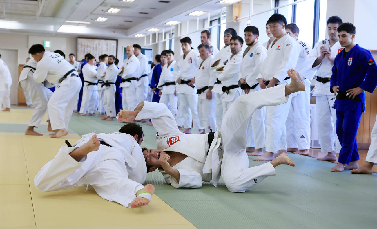 大勢の選手が見つめる中、乱取りでベカウリ（左）に投げられる村尾（撮影・浅見桂子）
