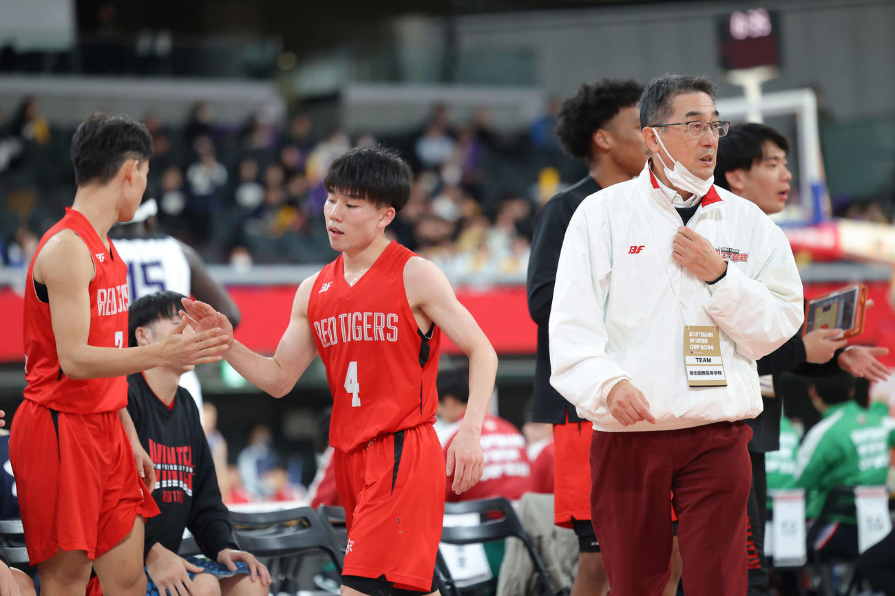 開志国際対北陸学院　第4Q、戦況を見守る富樫コーチ（右）。中央はベンチに下がる清水（撮影・河田真司）