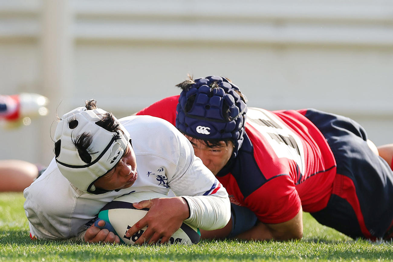 大分東明対常翔学園　前半、タックルを受けながらもトライを決める大分東明・石川（左）（撮影・前田充）