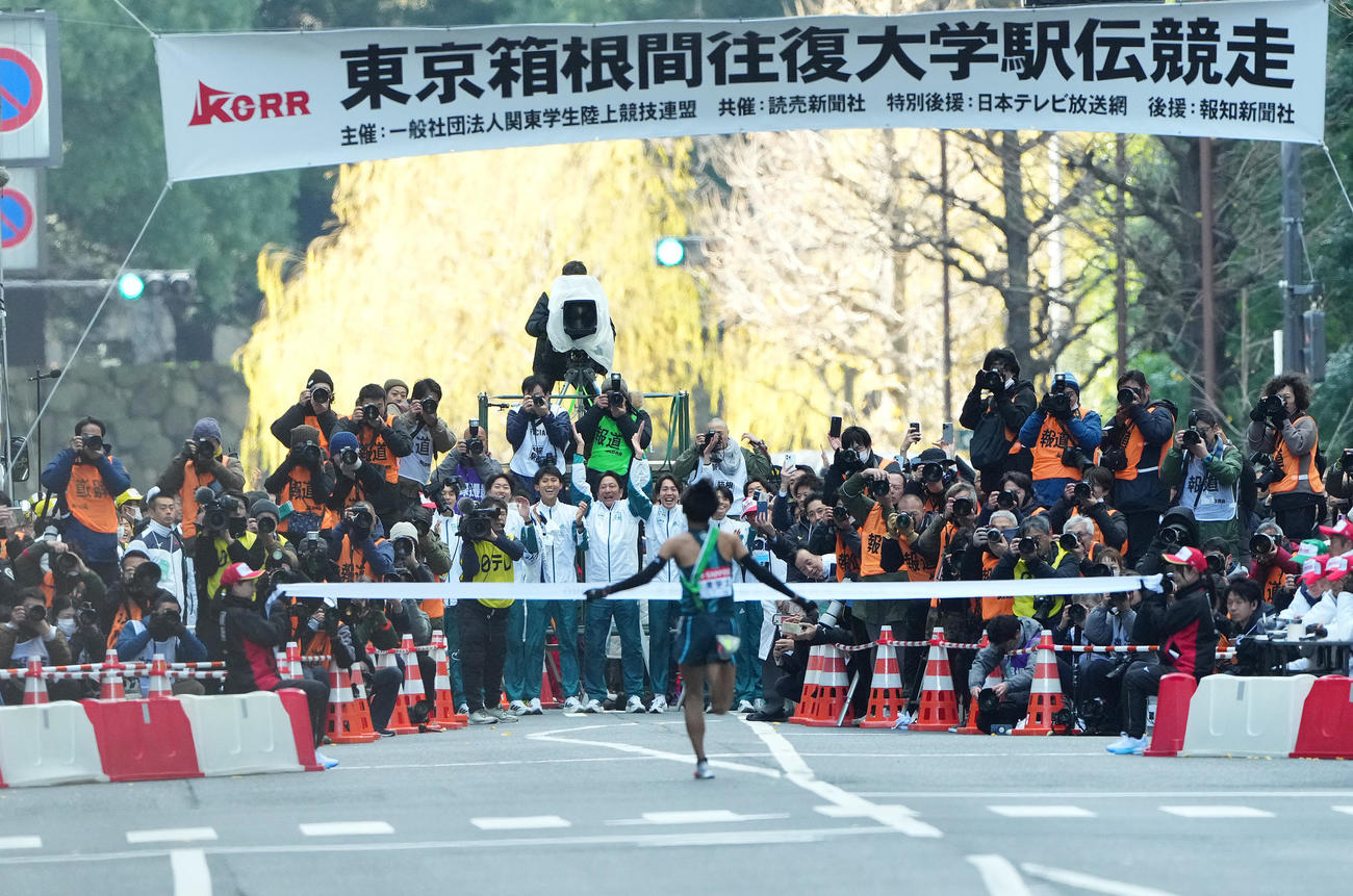 1位でゴールテープをきる青学大10区小河原陽琉を迎える原監督（中央）ら選手たち（撮影・菅敏）
