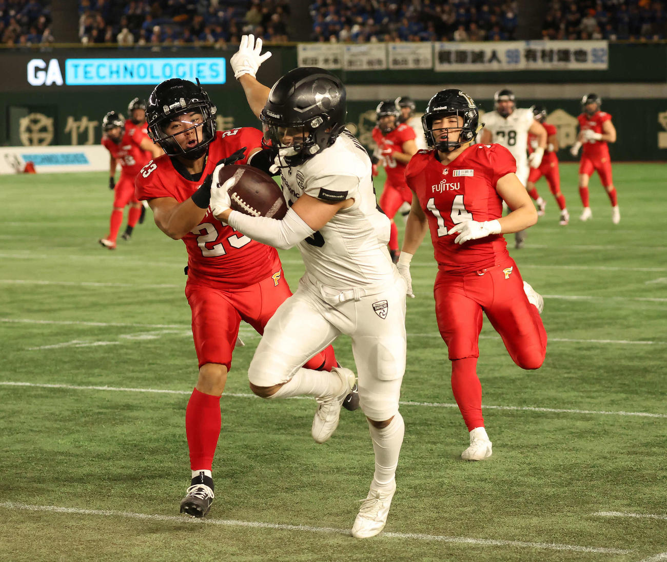 富士通対パナソニック　第2Q、パナソニックWR■（■は卉の下に木）田（右）がロングゲインして1stダウンを獲得（撮影・丹羽敏通）