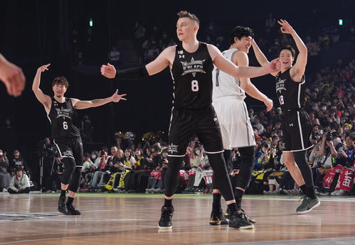 B．BLACK対B．WHITE　第4Q、3点シュートを決めた後、ポーズを取る比江島（左）。右から馬場、渡辺（撮影・鈴木みどり）
