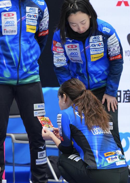ロコ・ソラーレ対中部電力 第5エンドを終え、グミを手に取るロコ・ソラーレ吉田知(下)(撮影・垰建太)
