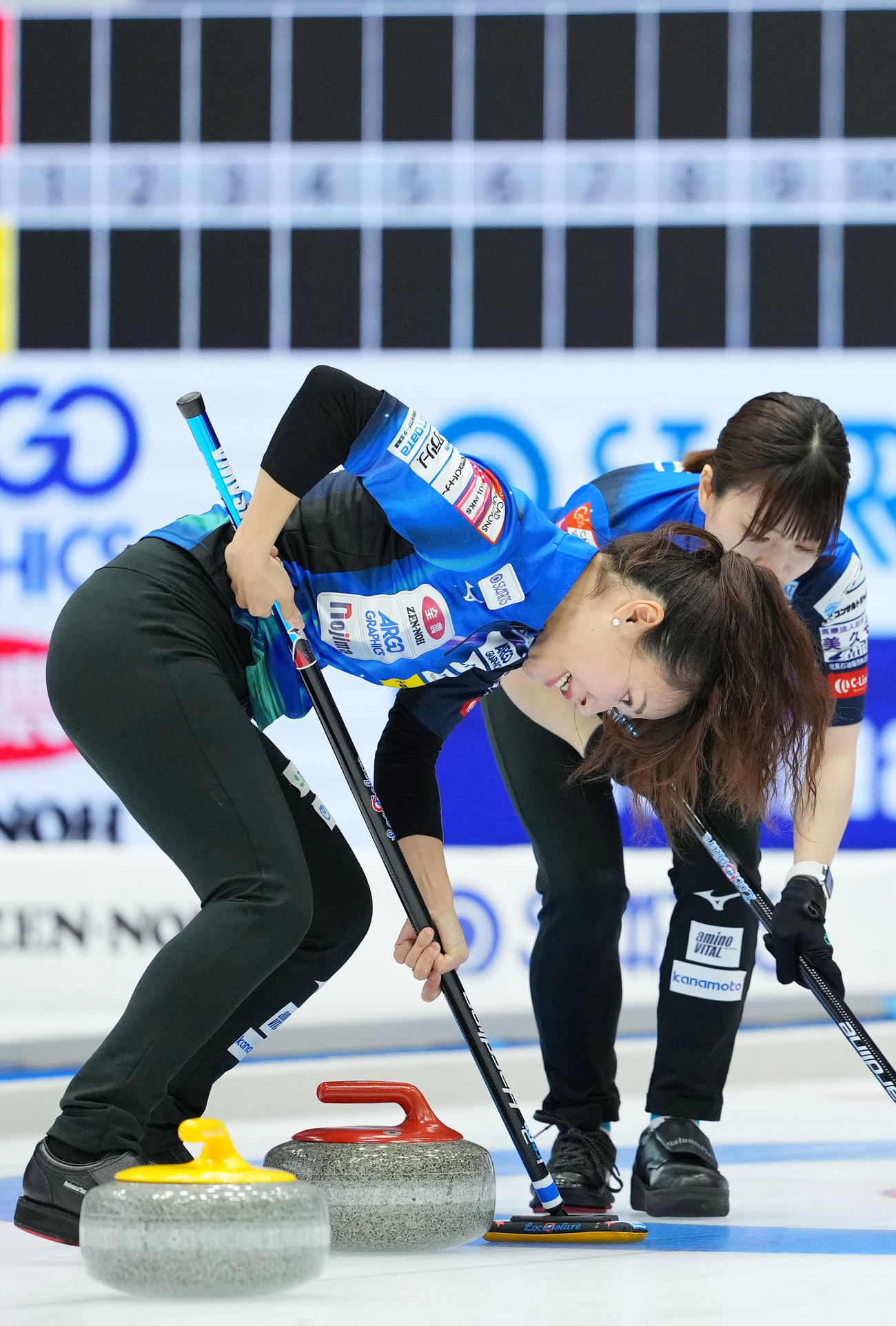 ロコ・ソラーレ対チーム御代田　第1エンド、スイープするロコ・ソラーレ吉田知（左）（撮影・横山健太）