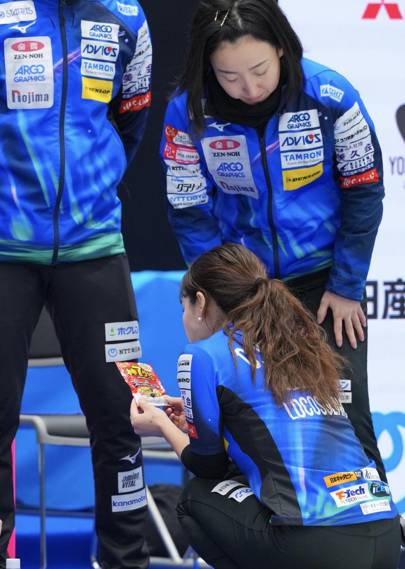 ロコ・ソラーレ対中部電力　第5エンドを終え、グミを手に取るロコ・ソラーレ吉田知（下）（撮影・垰建太）