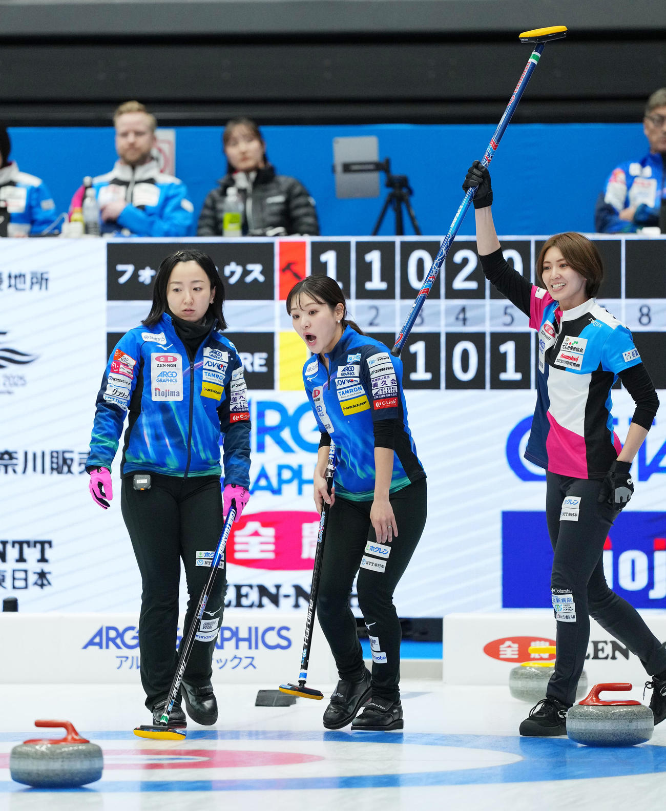 フォルティウス対ロコ・ソラーレ　第6エンド、スティックを掲げるフォルティウス吉村。左からロコ・ソラーレ藤沢、吉田知（撮影・横山健太）