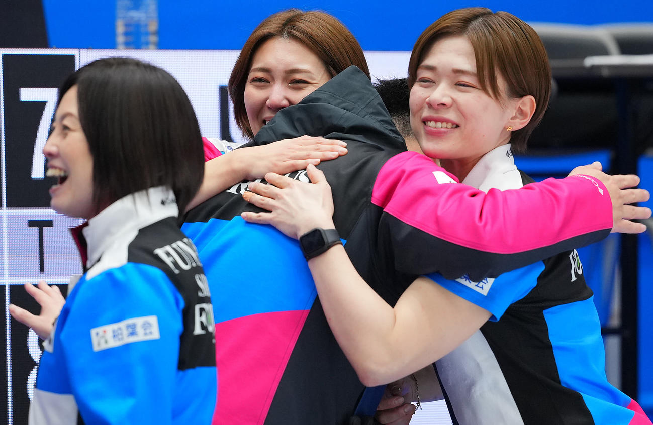 フォルティウス対北海道銀行　優勝し関係者と笑顔で抱き合うフォルティウス吉村（中央）と小野寺（右）（撮影・垰建太）