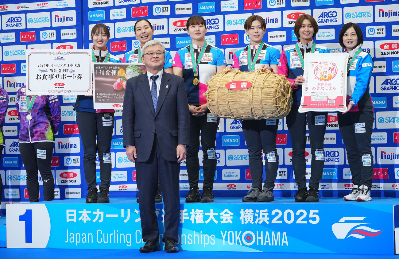 女子優勝のフォルティウスの選手たちは折原敬一全農経営管理委員会会長（手前）と写真に納まる。左から小林、近江谷、小谷、小野寺、吉村、船山コーチ（撮影・垰建太）