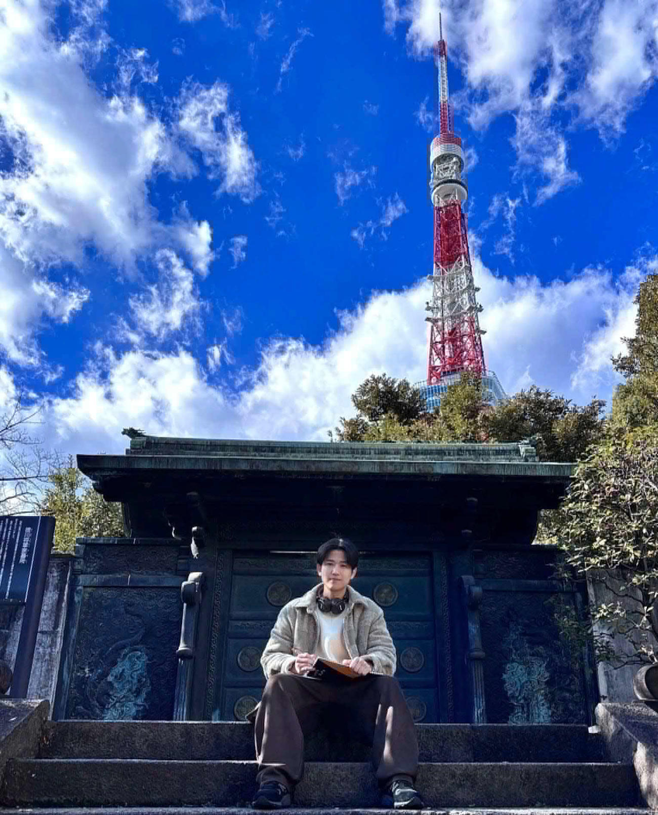 個展を開く田村さん。東京タワーを臨む増上寺の山門の前で