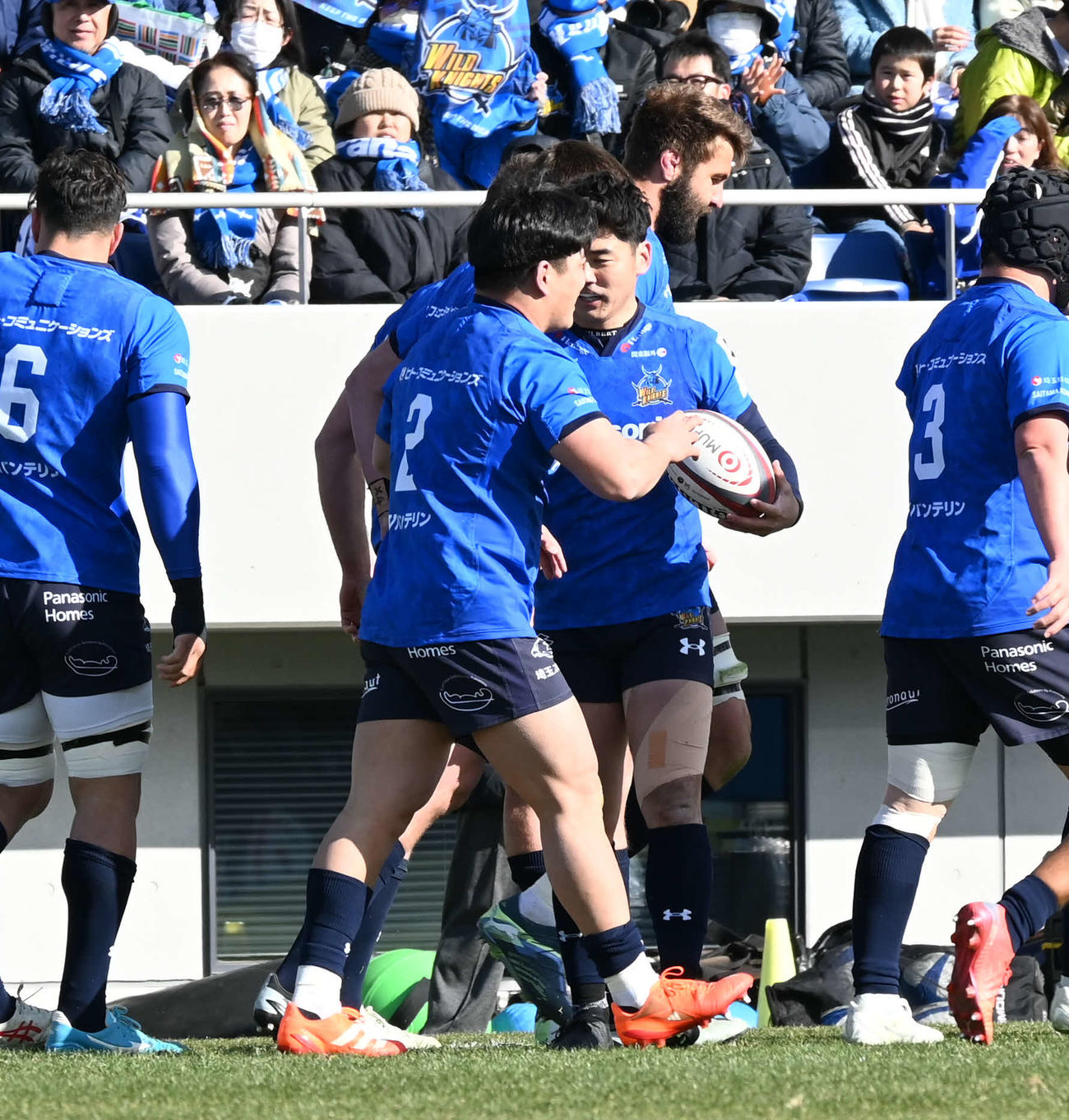 前半、トライを決めてチームメートに祝福される埼玉の佐藤（撮影・飯岡大暉）