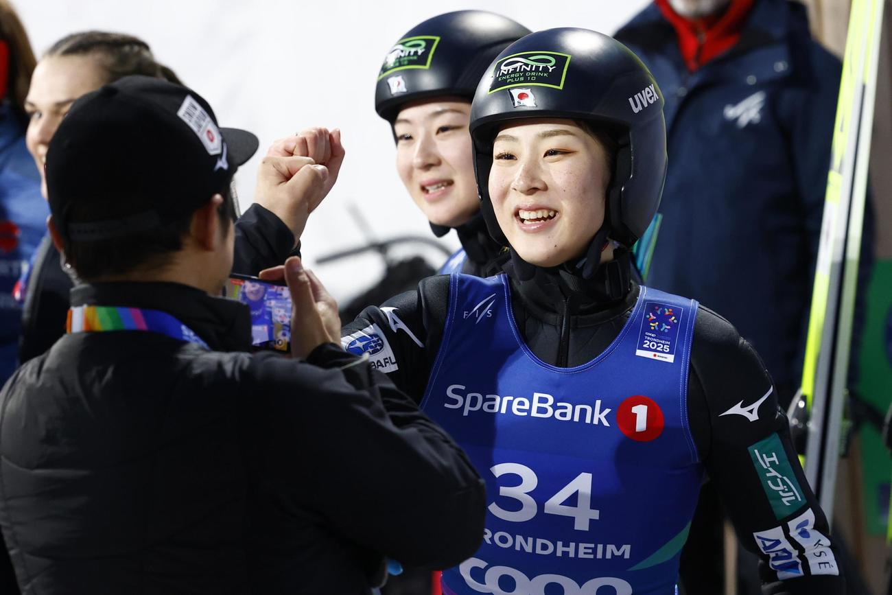 ノルディック世界選手権の複合女子で優勝を決め、関係者とタッチを交わす葛西優奈（手前右）。奥は3位に入った双子の妹の春香＝トロンヘイム（共同）