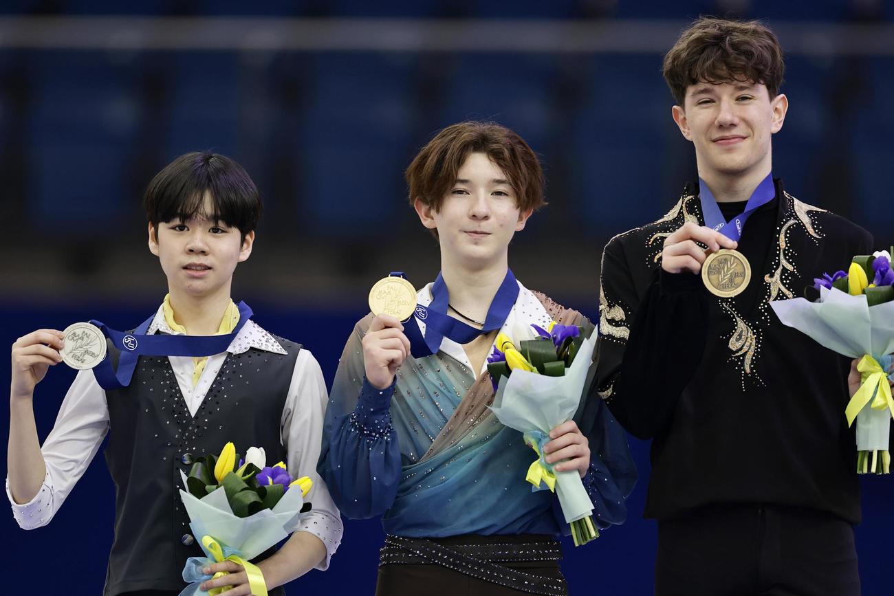 男子で優勝し、表彰式で金メダルを掲げる中田璃士（中央）（共同）