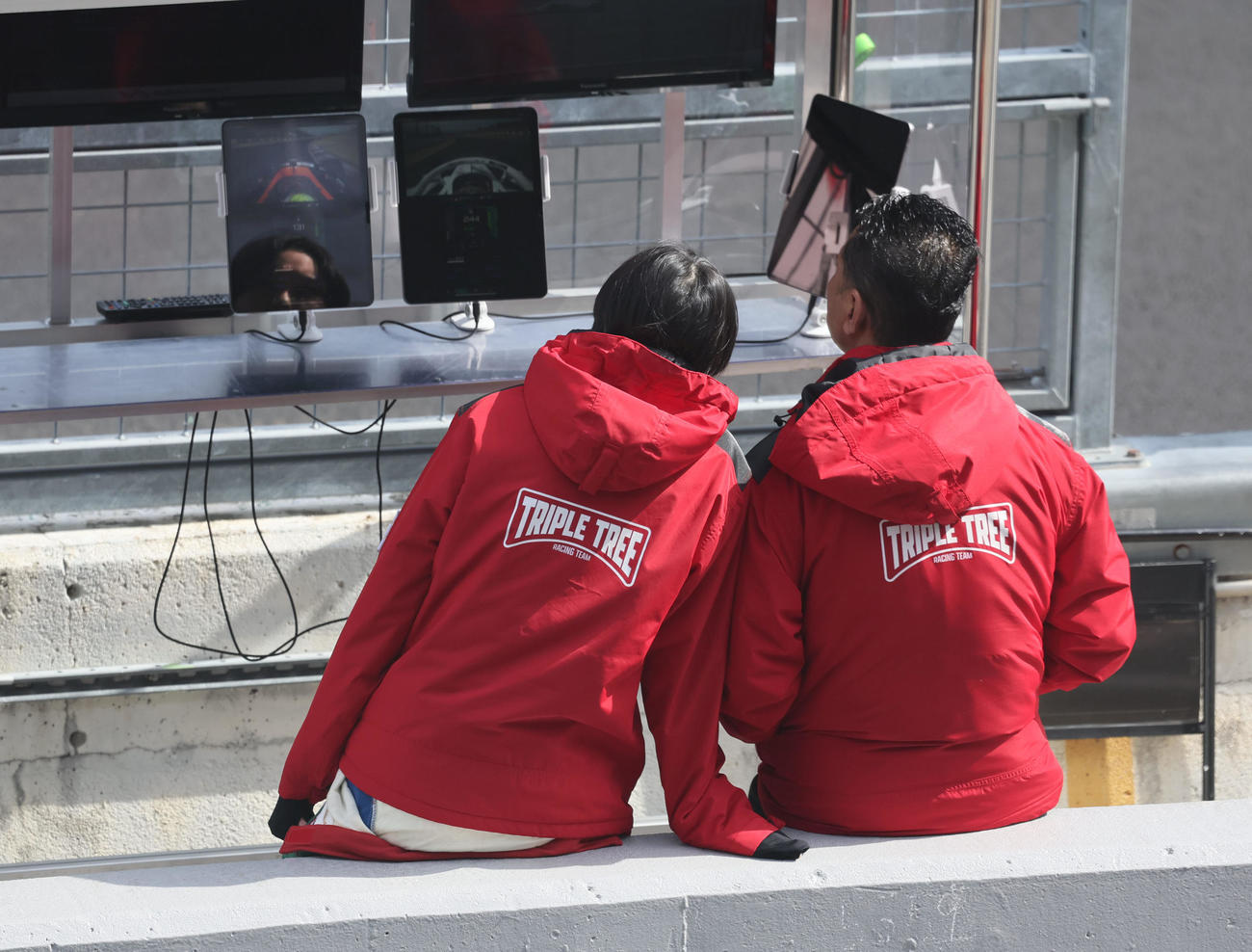 スーパーフォーミュラ第1戦　予選を終えピットウォールに座り、他組のタイムモニターを見つめるJujuと父の野田英樹監督（撮影・宮崎幸一）