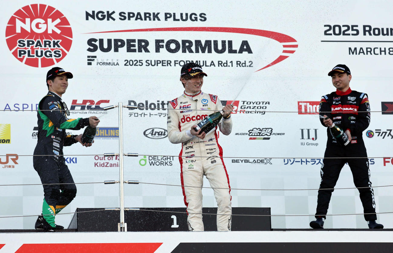 スーパーフォーミュラ第2戦の表彰台でスパークリング日本酒を掛け合う、左から2位の坪井翔、優勝したDOCOMO TEAM DANDELION RACINGの牧野任祐、3位の岩佐歩夢（撮影・宮崎幸一）
