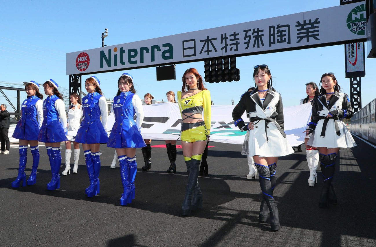 スーパーフォーミュラ第2戦、スタート進行で巨大なフラッグを支える各チームのキャンペーンガール（撮影・宮崎幸一）