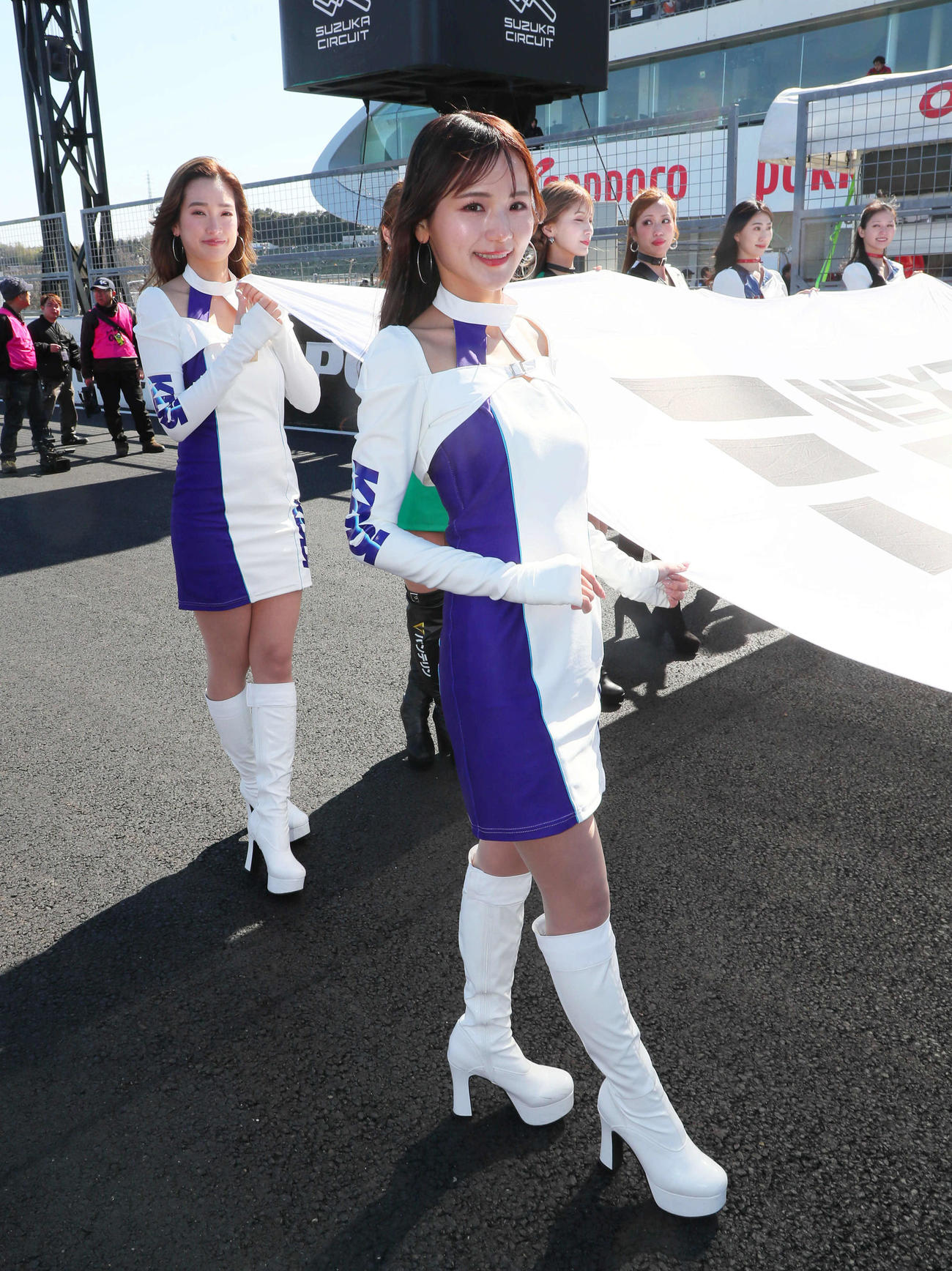 スーパーフォーミュラ第2戦、スタート進行で巨大なフラッグを支えるKDDI TGMGPのキャンペーンガール（撮影・宮崎幸一）