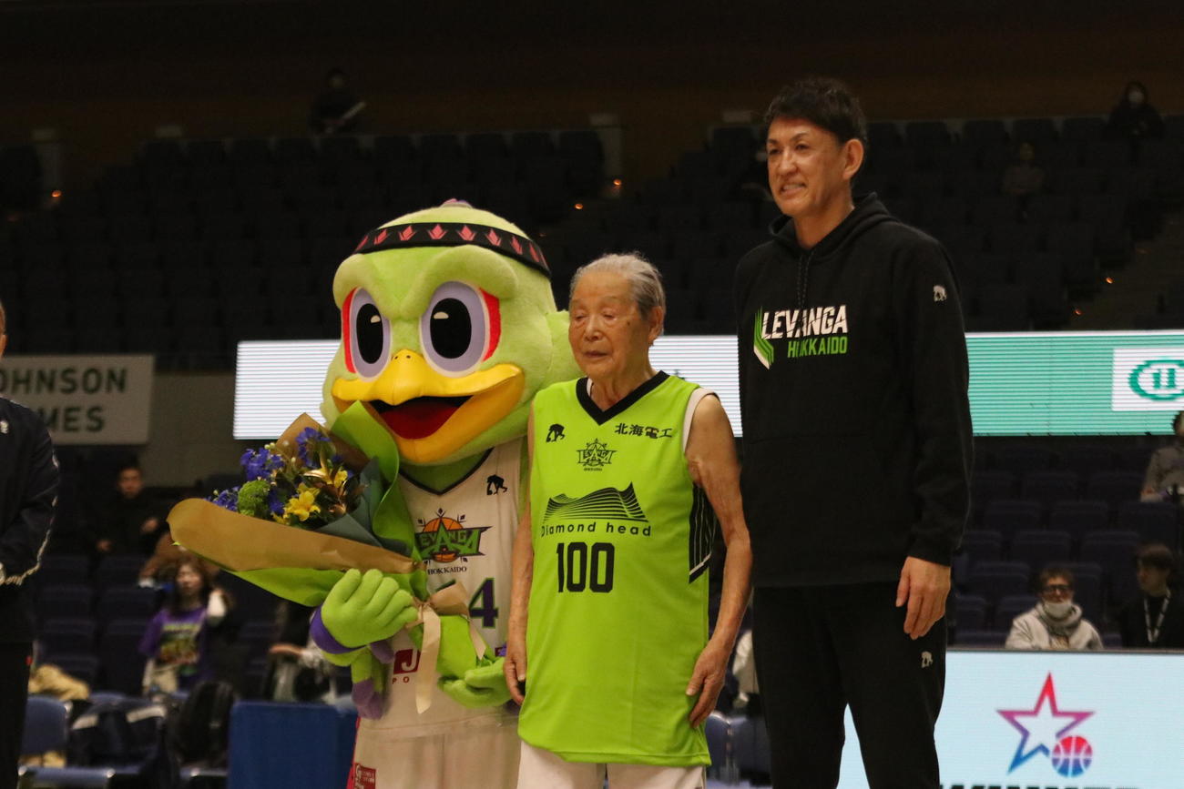 引退試合に臨んだ在間さん（中央）はレバンガ北海道折茂社長（右）から年齢と同じ100番のユニホームを贈呈される（撮影・保坂果那）