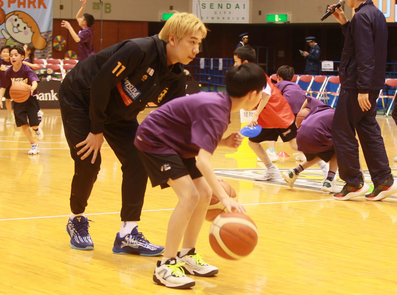 子どもたちとともに腰を落としドリブルをするB1仙台SF荒谷（撮影・高橋香奈）