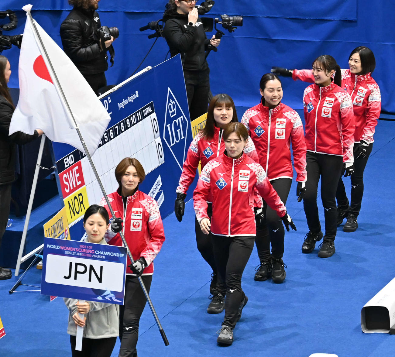 カーリング女子世界選手権開会式で入場する女子日本代表の手前から吉村、小野寺、小谷、近江谷、小林、船山コーチ（撮影・飯岡大暉）