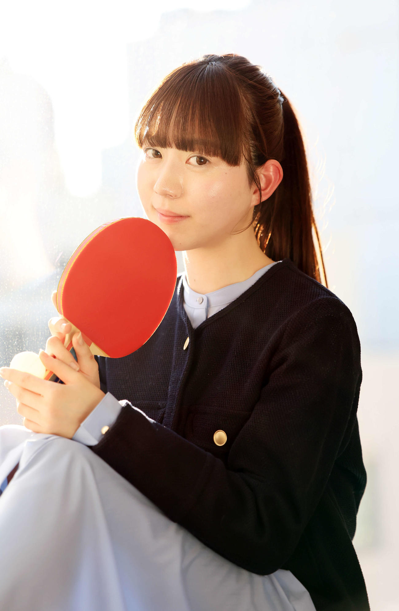 2025年2月25日、来社した“卓球天使”の菊池日菜はラケットを手にほほ笑む（撮影・浅見桂子）