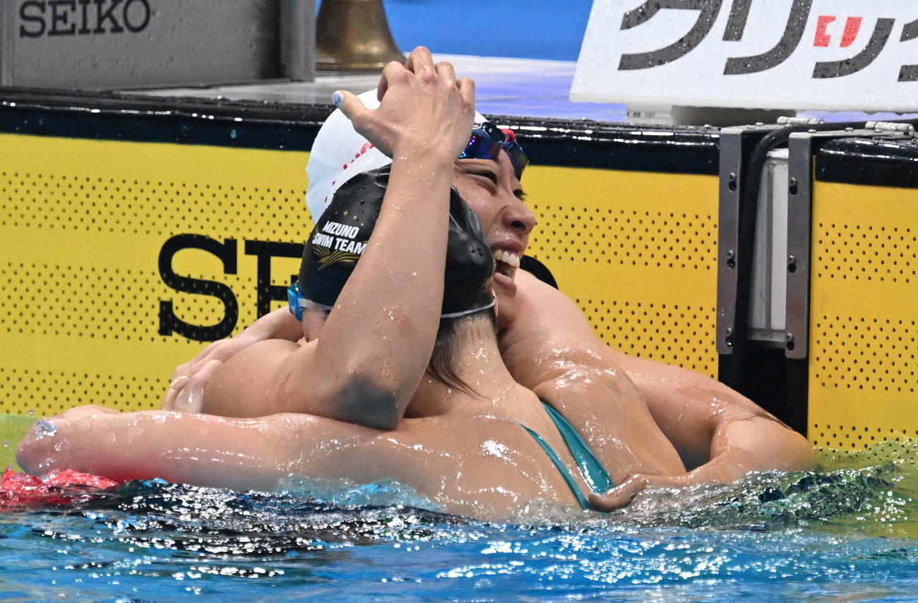 女子100メートル平泳ぎ決勝　1分06秒21で優勝し、2位の青木と健闘をたたえ合う鈴木（左）。ともに代表入りした（撮影・千葉一成）