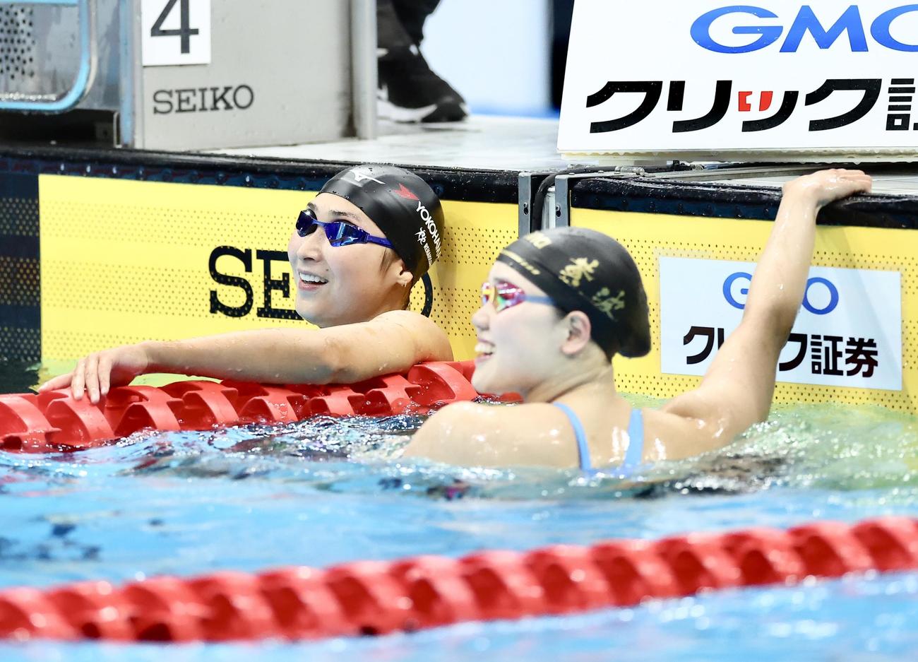 女子50メートルバタフライ決勝　レースを終え笑顔を見せる優勝の池江（左）と2位の平井（撮影・河田真司）