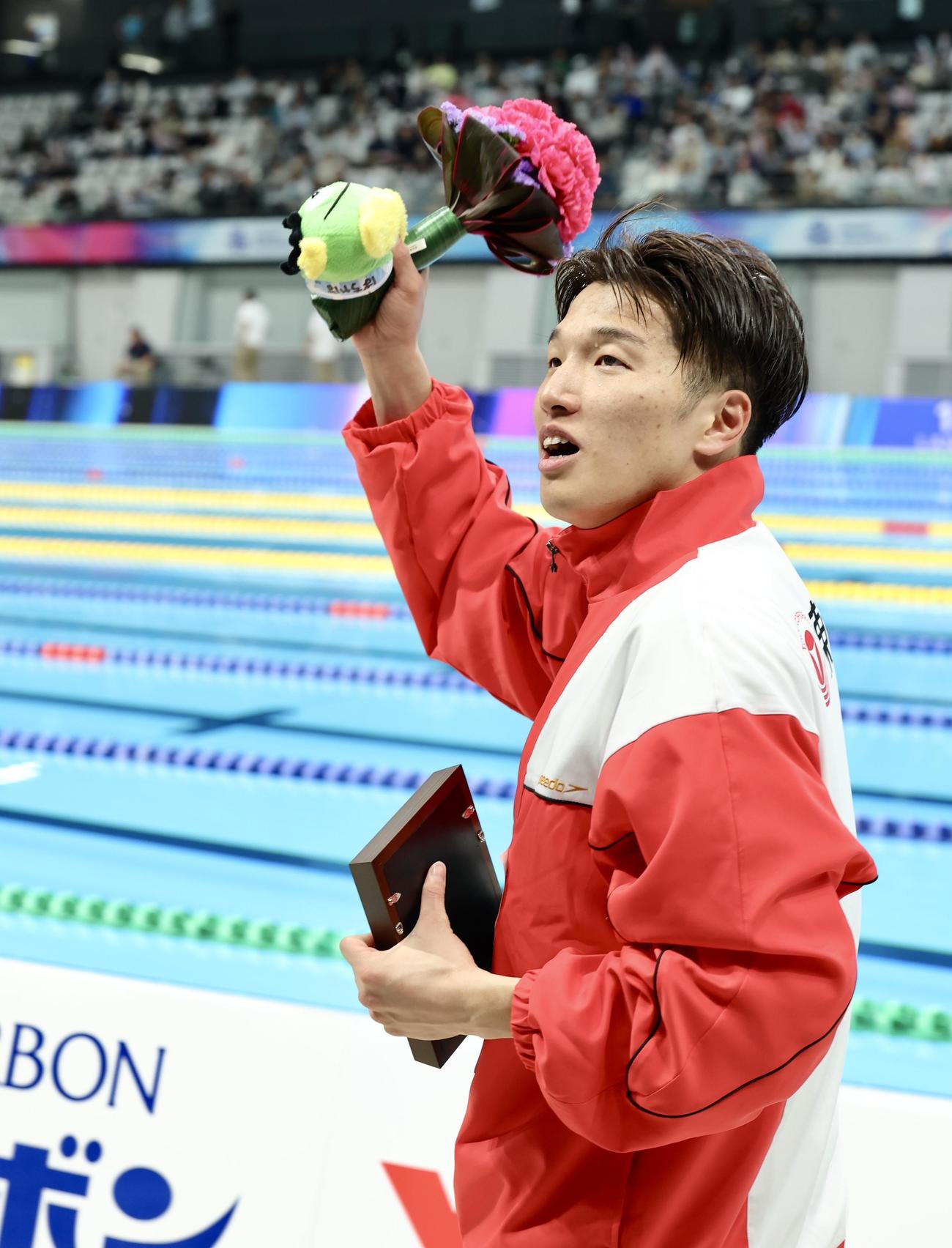 男子200メートル平泳ぎで世界選手権内定を決め、観客の声援に応えながら引き揚げる深沢（撮影・河田真司）