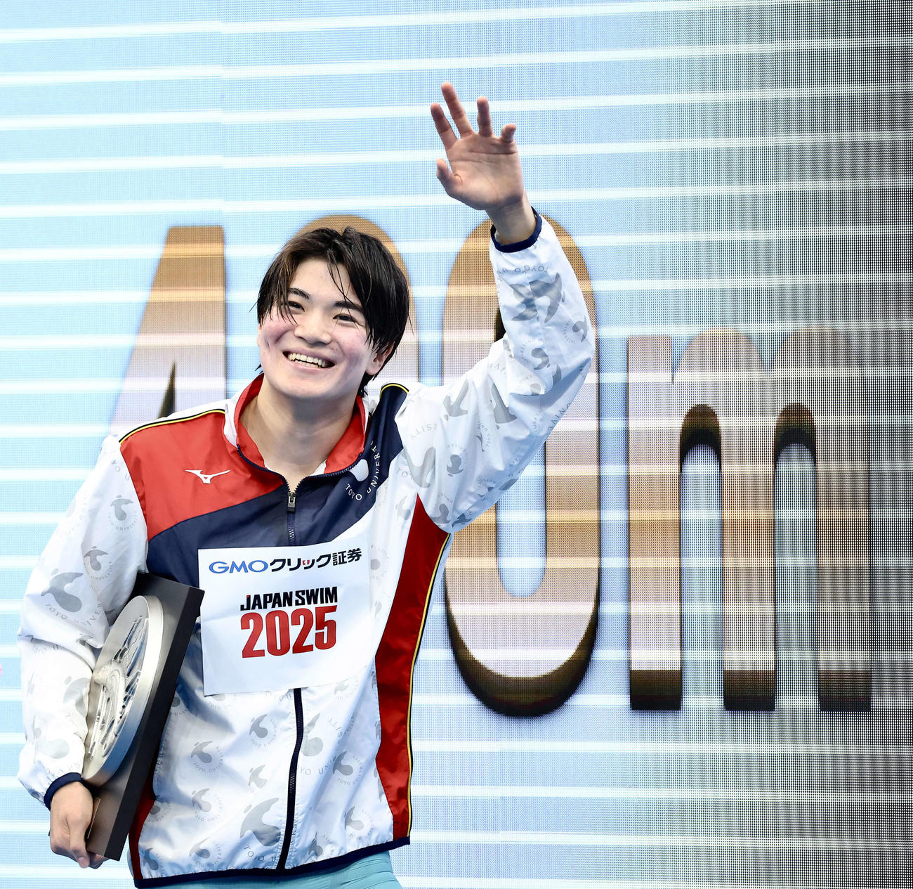 表彰式を終え、観客の声援に笑顔で答える男子400メートル個人メドレー優勝の松下（撮影・河田真司）