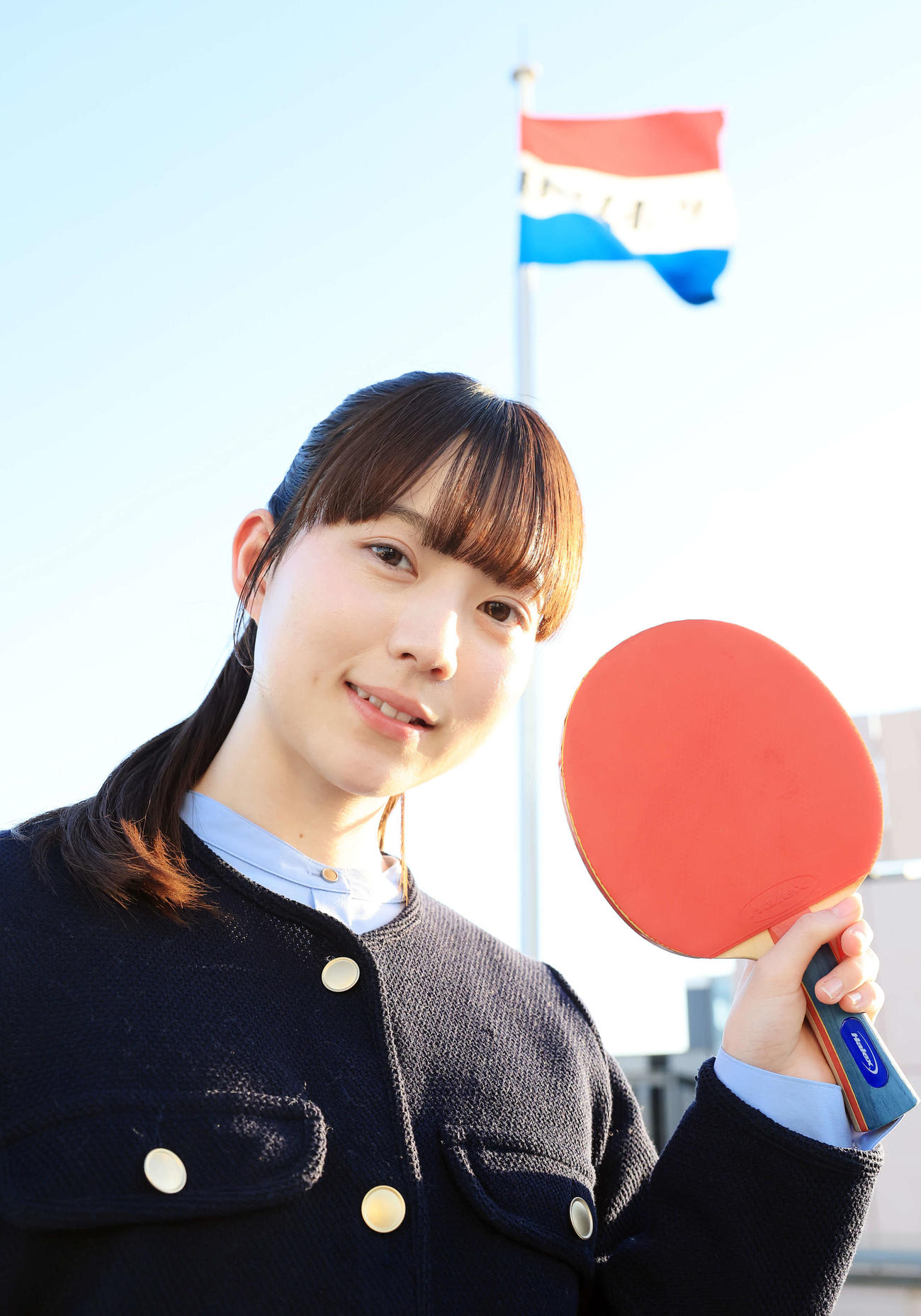 2月、来社した“卓球天使”の菊池日菜は日刊スポーツの社旗を背にほほ笑む