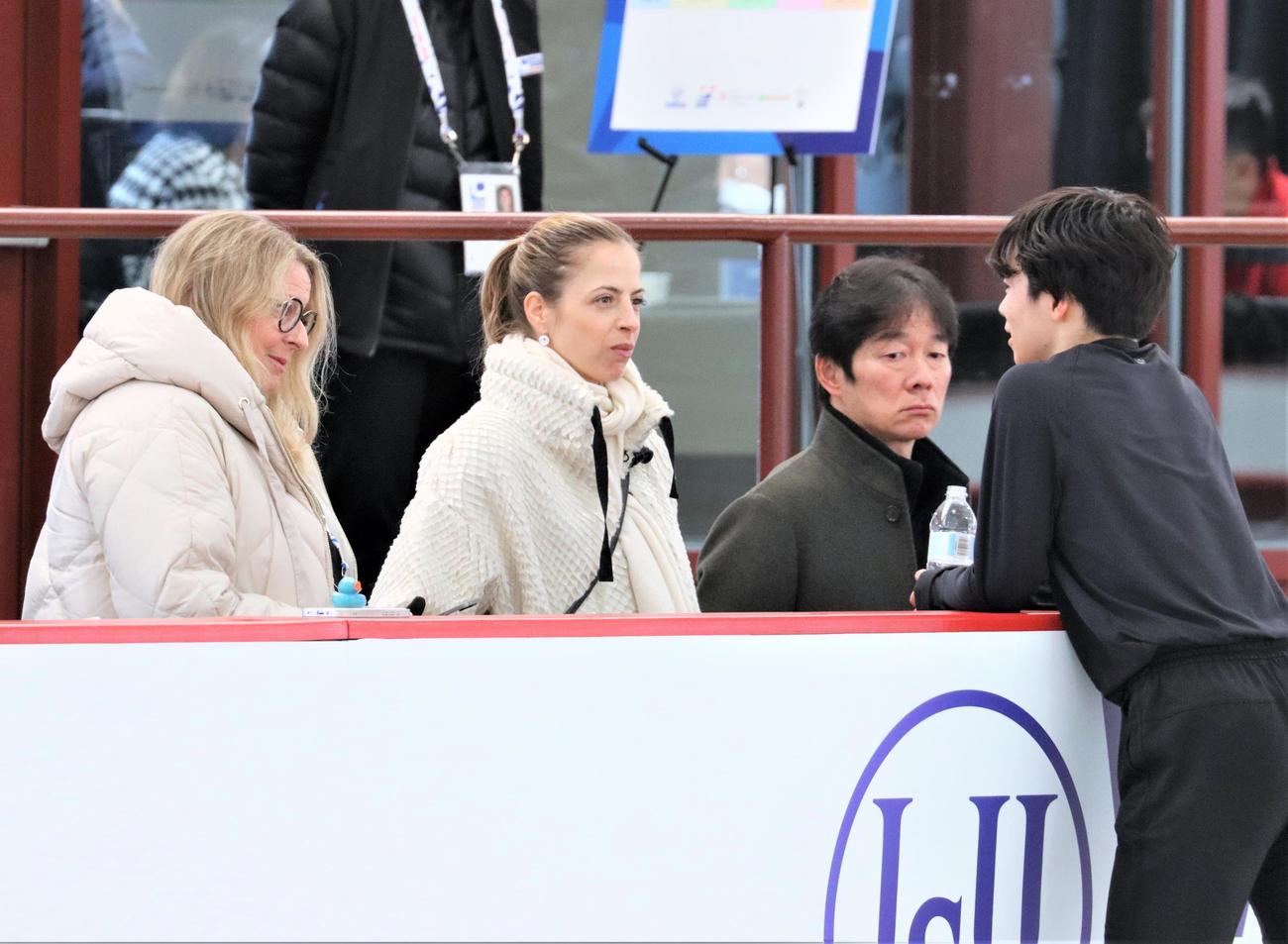 世界選手権の公式練習中に話し合う、左からローリー・ニコル、カロリーナ・コストナー、鍵山正和、鍵山優真（撮影・藤塚大輔）