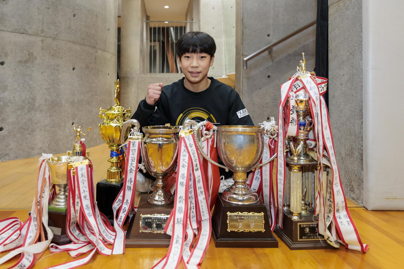 トロフィーの前でガッツポーズする豊栄ジュニア・天野