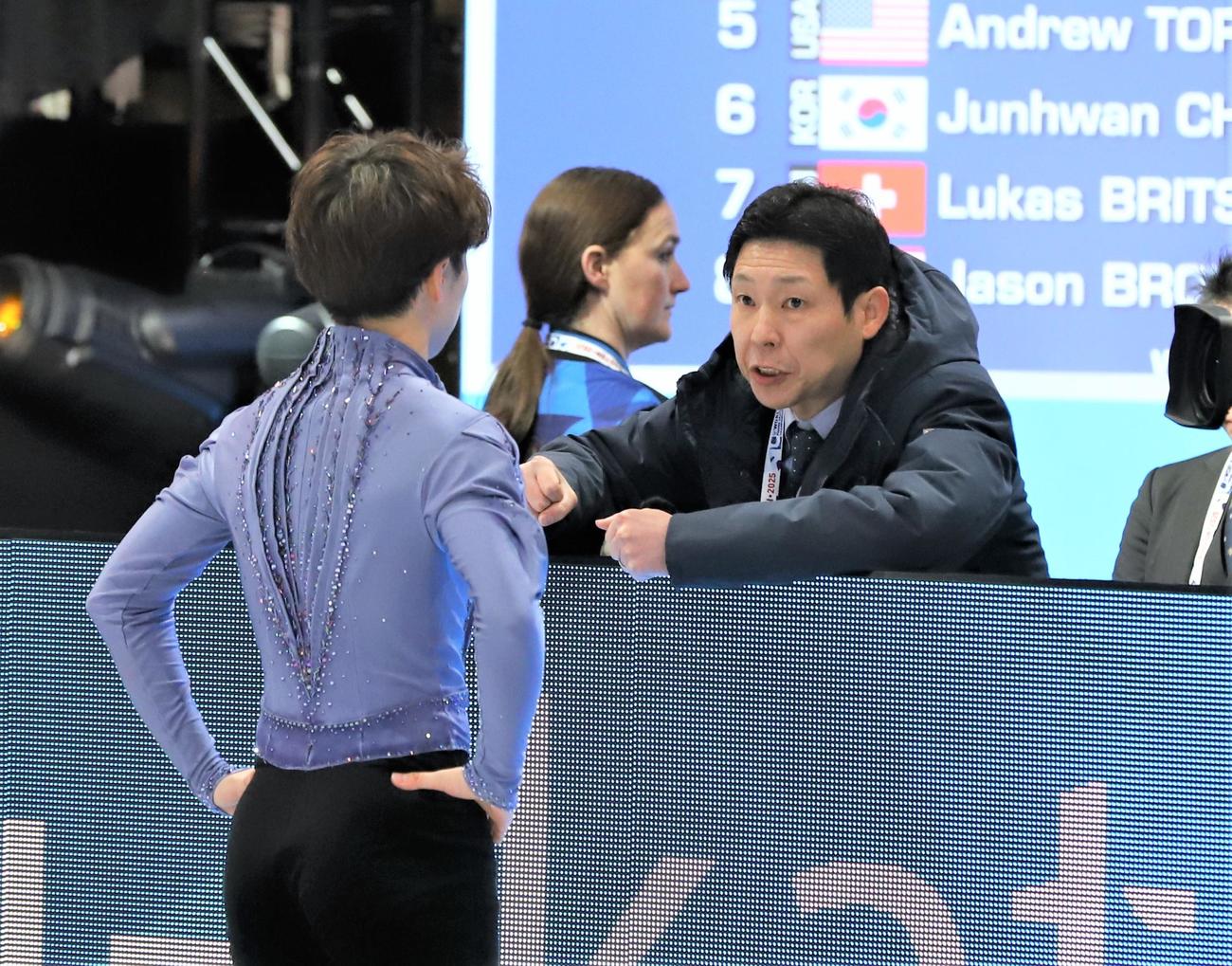 世界選手権男子SPへ佐藤駿（左）を送り出す日下匡力コーチ（撮影・藤塚大輔）