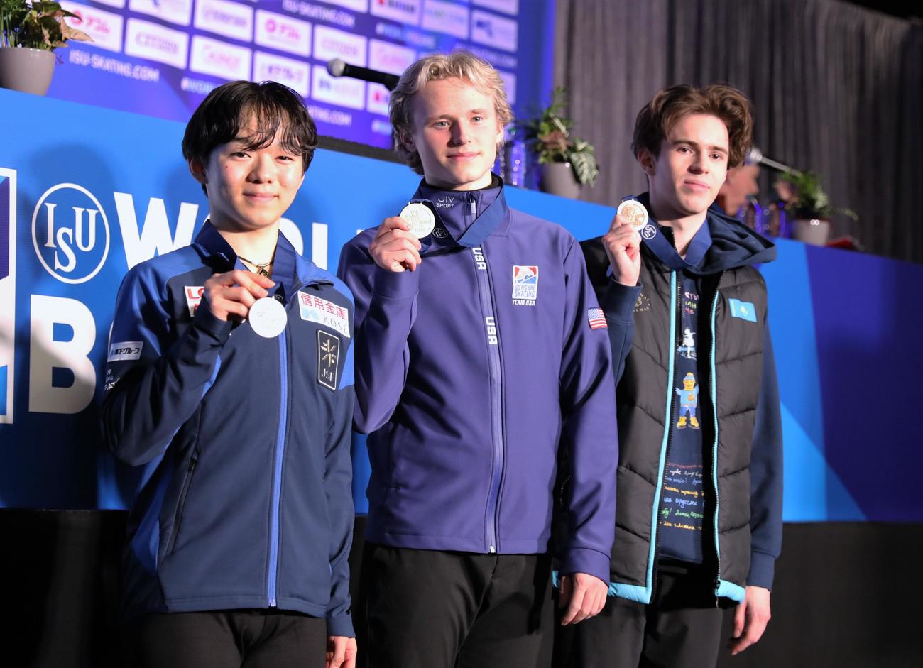 世界選手権男子SP後の会見でメダルを掲げる、左から2位の鍵山、1位のマリニン、3位のシャイドロフ（撮影・藤塚大輔）