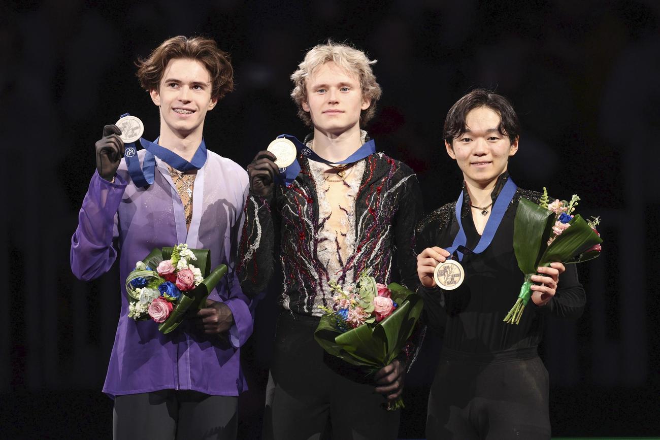 男子の表彰式でメダルを掲げる（右から）3位の鍵山優真、優勝のイリア・マリニン、2位のミハイル・シャイドロフ＝ボストン（共同）