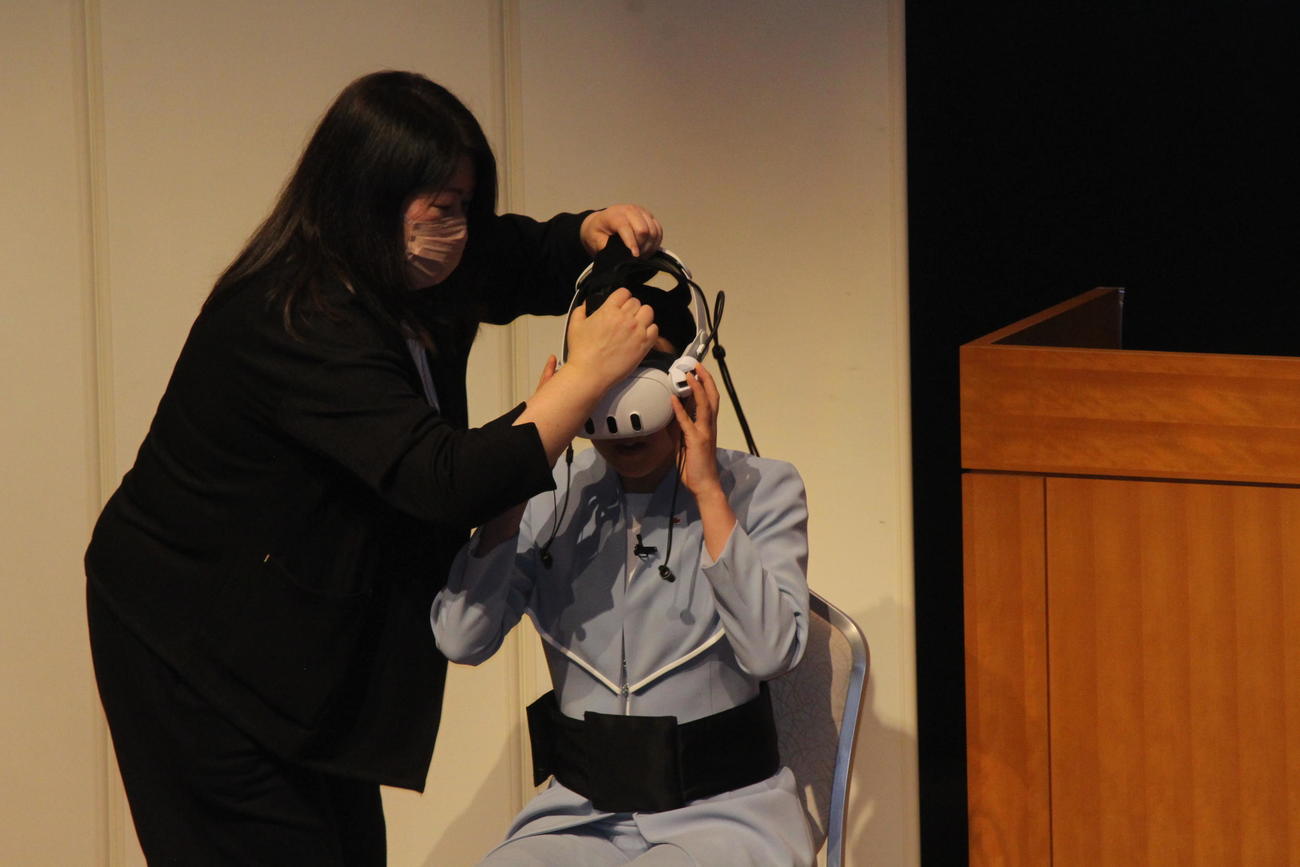 「万博VRお披露目会」でVRゲームの装置をつける浅田さん