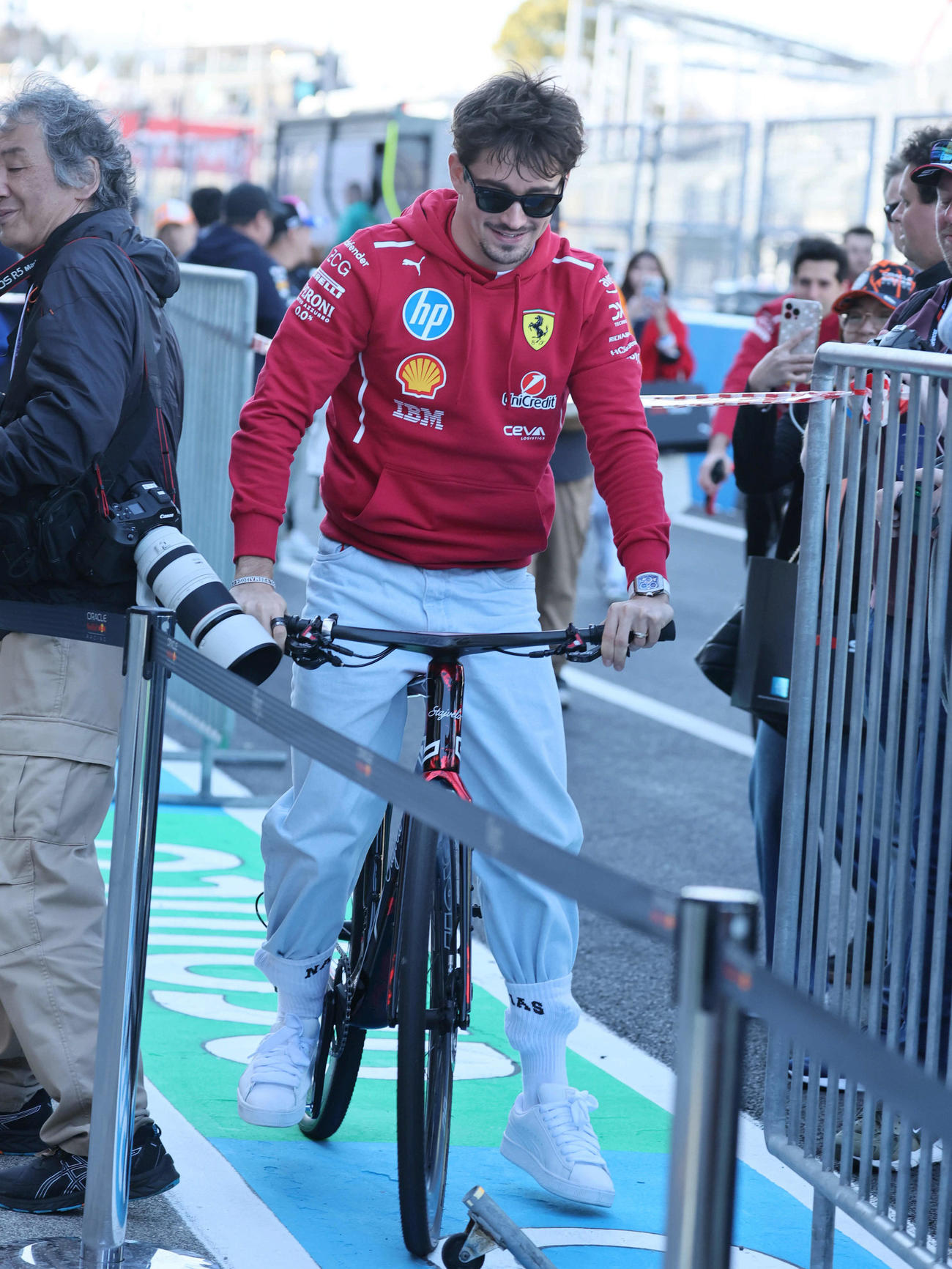ピットロードを自転車で走ってきたフェラーリのシャルル・ルクレールは、ファンで溢れる状況に狭い所にはまり込む（撮影・宮崎幸一）
