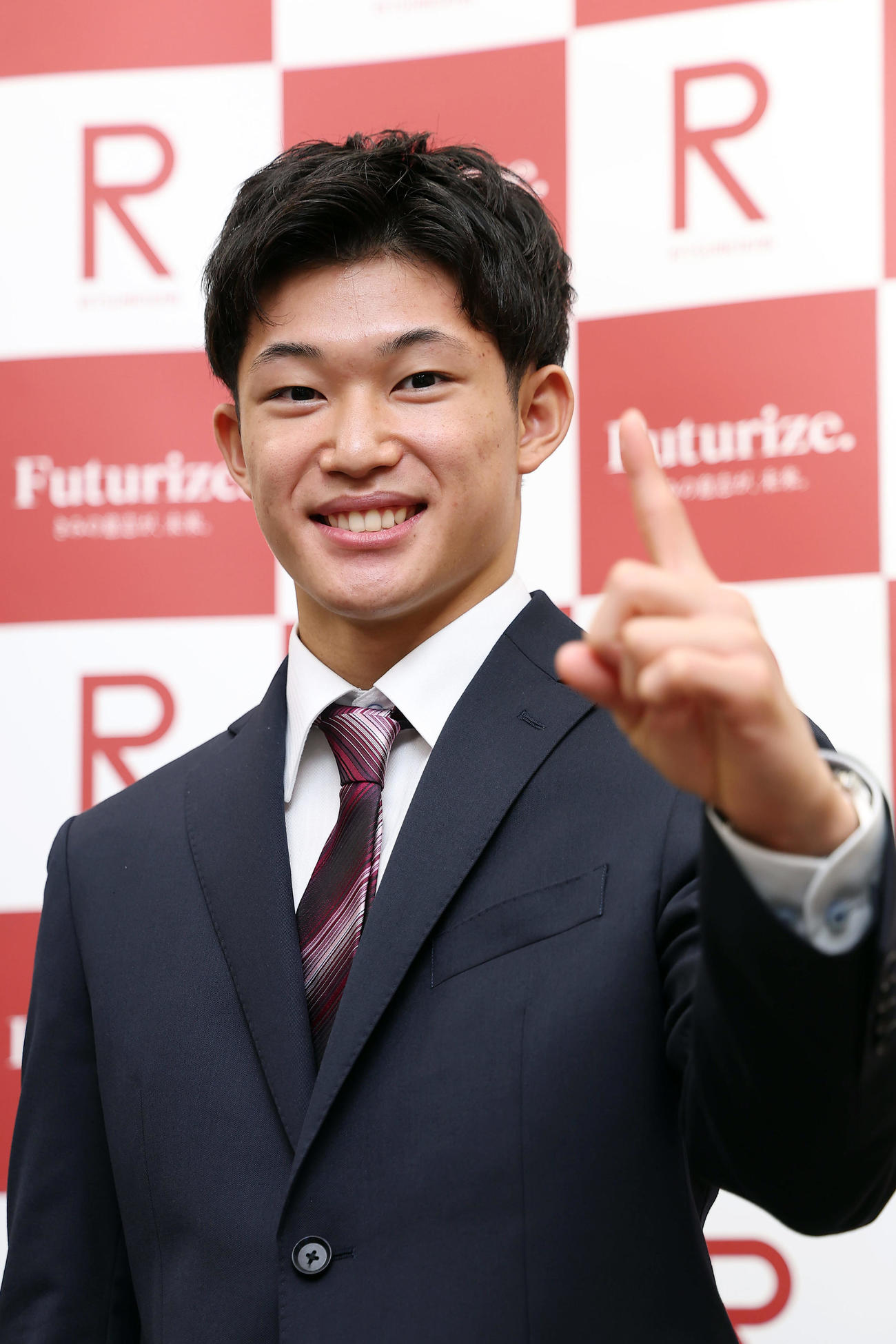 立命大の入学式に出席し、笑顔でポーズをとる男子高飛び込みの玉井（撮影・前田充）