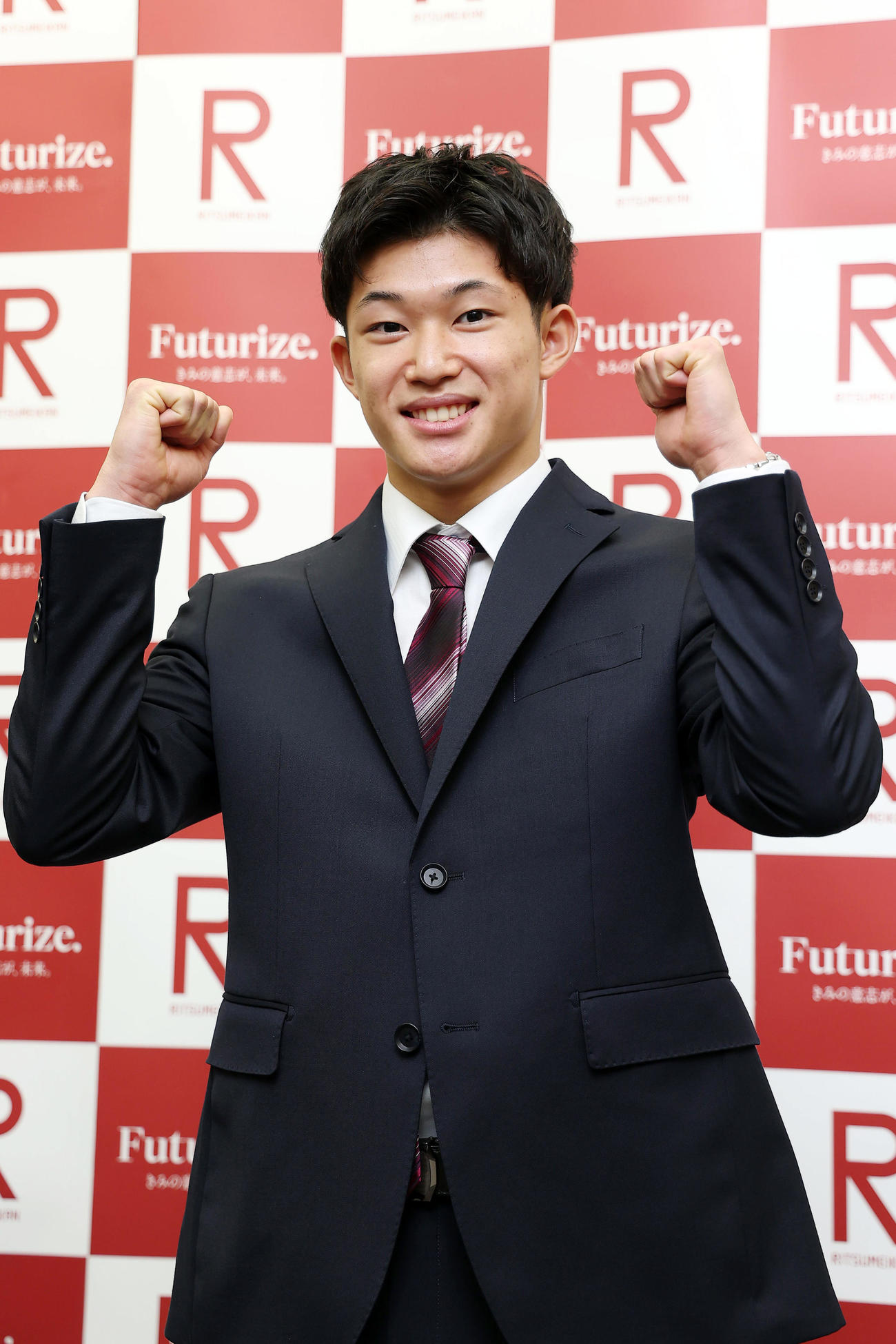 立命大の入学式に出席し、笑顔でポーズをとる男子高飛び込みの玉井（撮影・前田充）