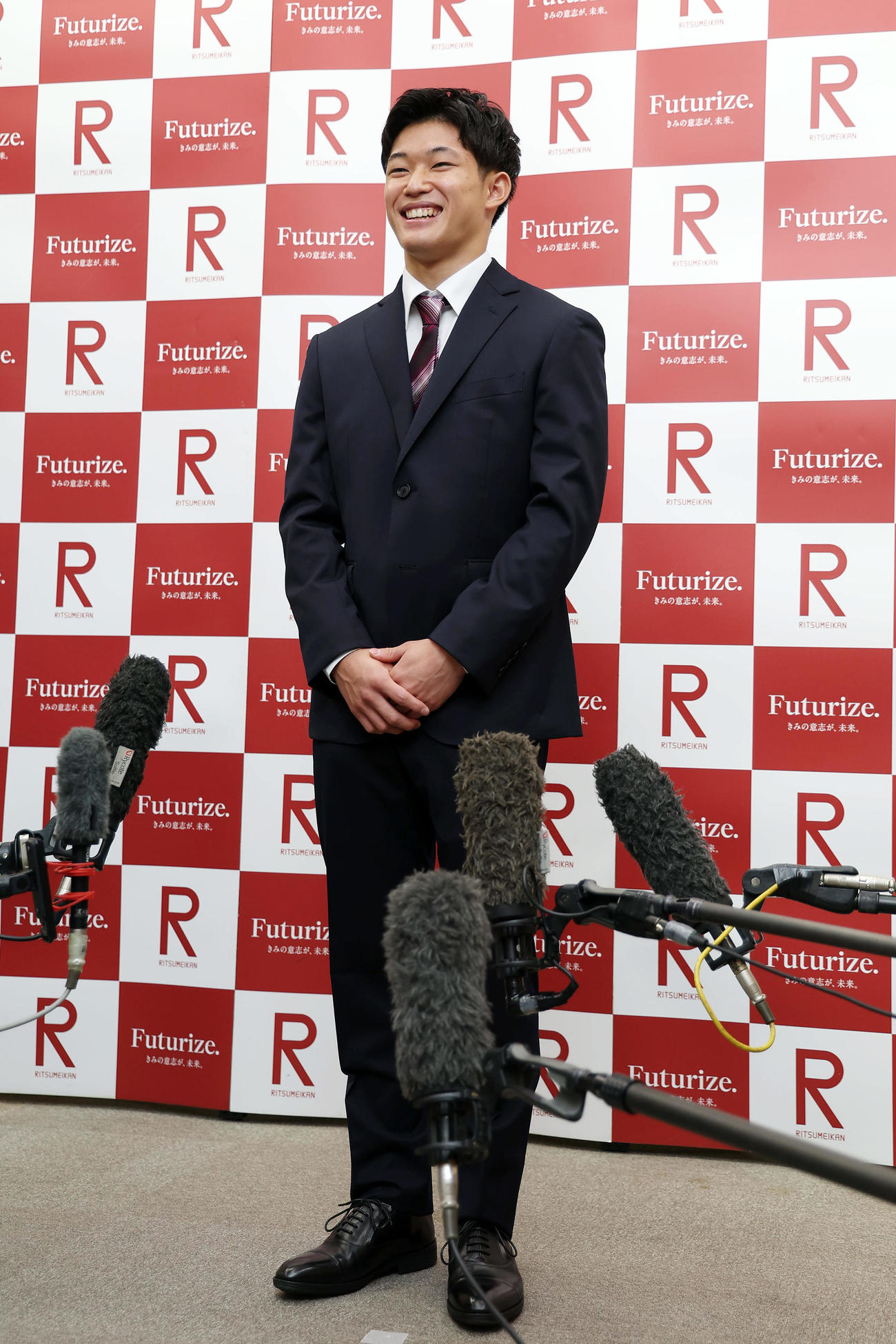 立命大の入学式に出席し、笑顔を見せながら取材に応じる男子高飛び込みの玉井（撮影・前田充）