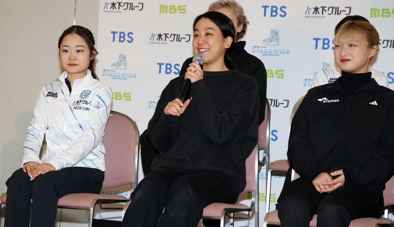 会見で島田麻央（左）から「浅田さんに聞きたいこと」を受け笑顔で答える浅田真央。右は坂本花織（撮影・加藤哉）