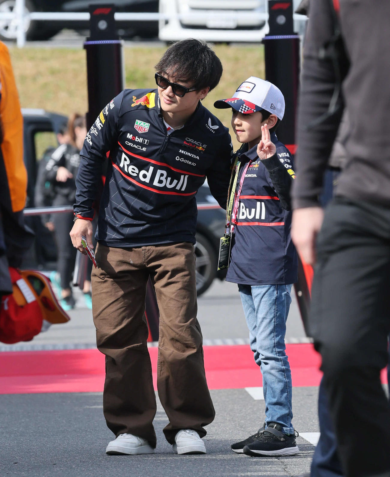 ファンと記念撮影しながらパドック入りするレッドブル・ホンダの角田裕毅（撮影・宮崎幸一）