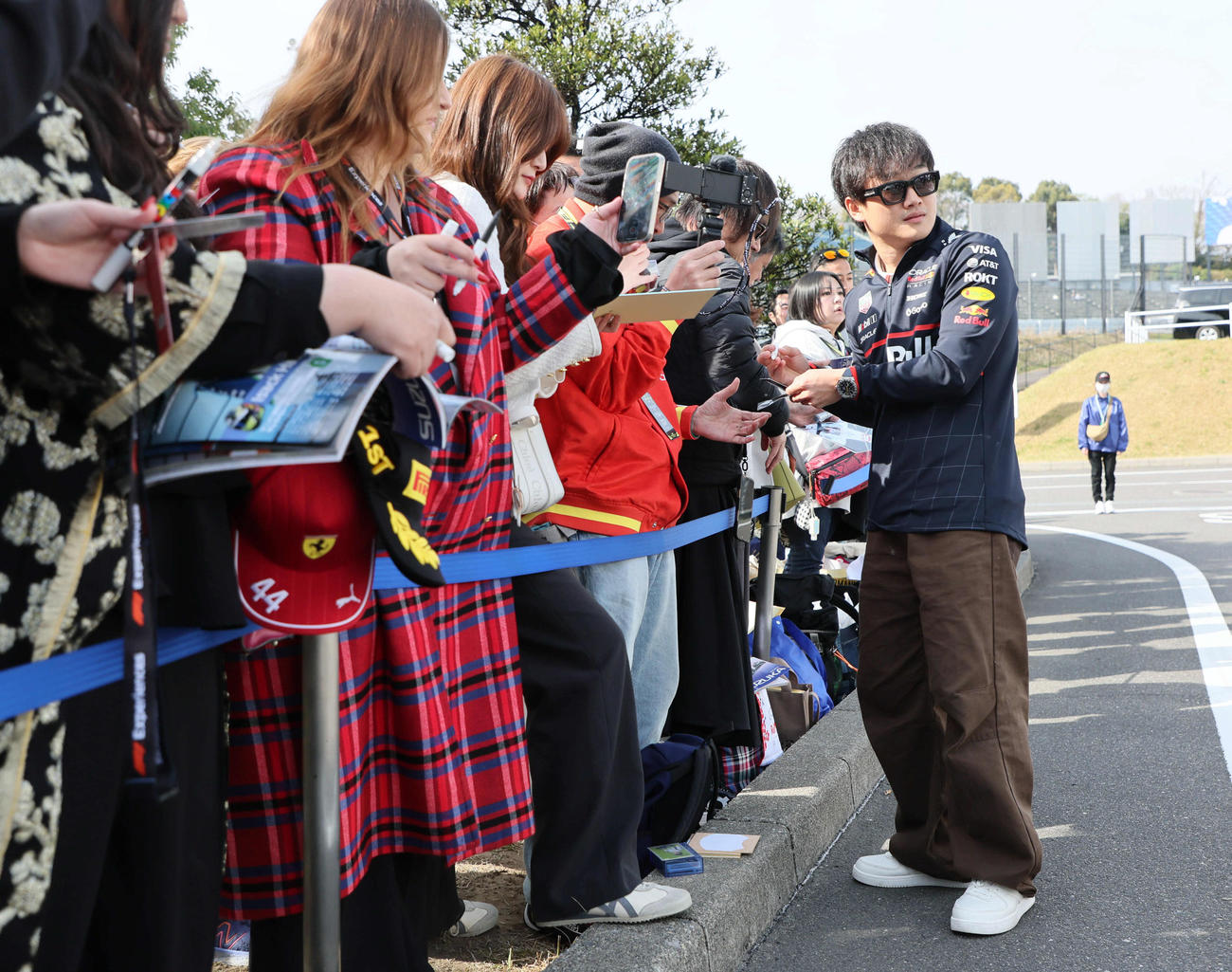 ファンにサインしながらパドック入りするレッドブル・ホンダの角田裕毅（撮影・宮崎幸一）
