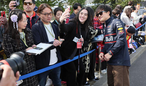 ファンにサインしながらパドック入りするレッドブル・ホンダの角田裕毅（撮影・宮崎幸一）